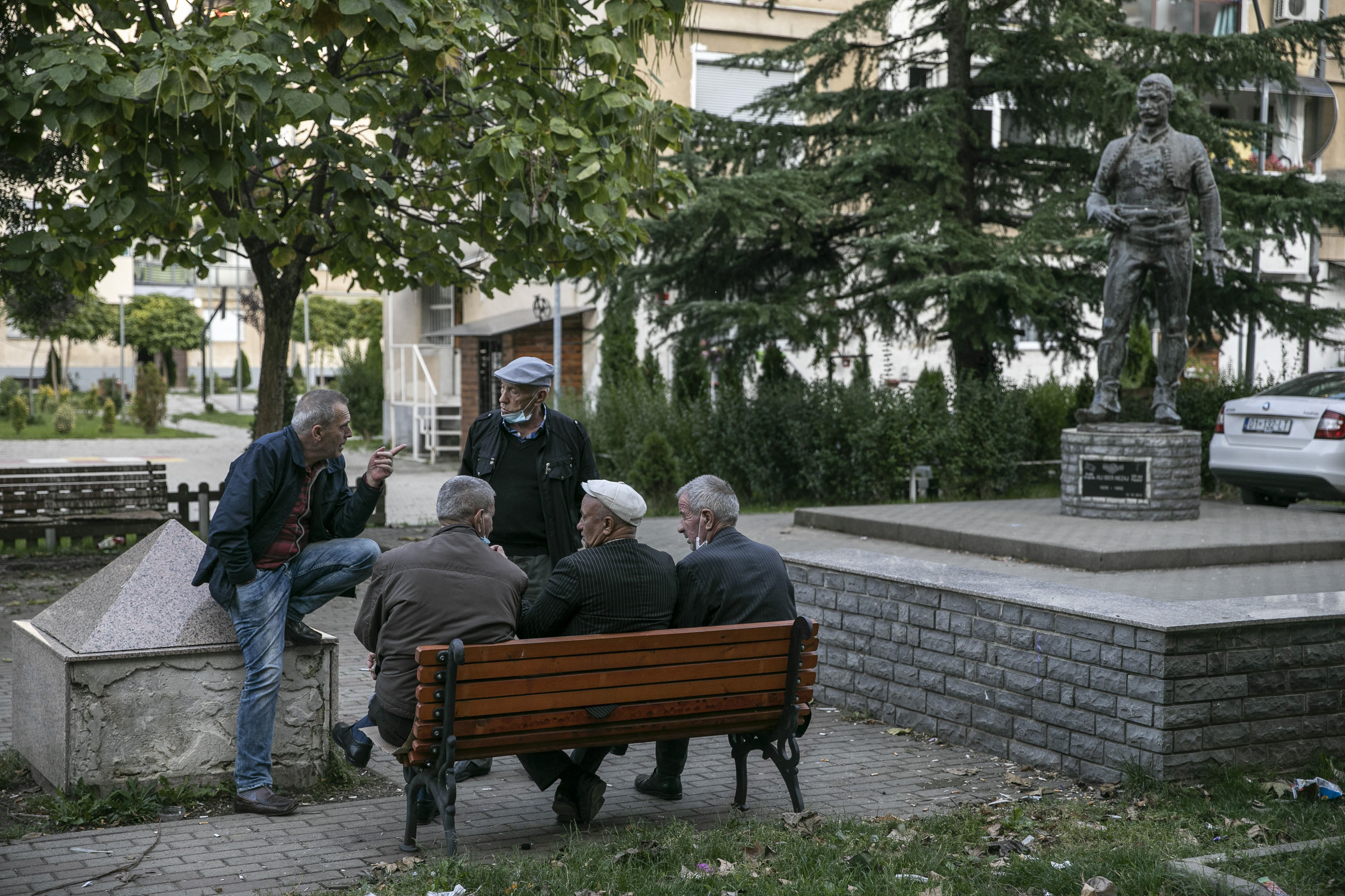 Elderly men chatting at a square in Gjakova.
